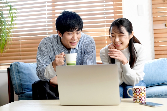 パソコンの前で相談する男女のイメージ